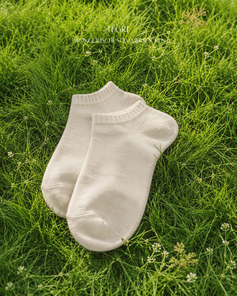 Wollsocken Sneaker-Schnitt, Mongolische Wolle, Naturweiß, auf der Wiese